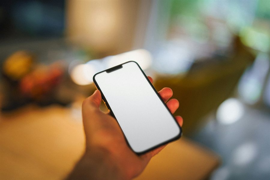 A hand holding a phone with a blank screen in warm light, standing in for the Site Bite chat