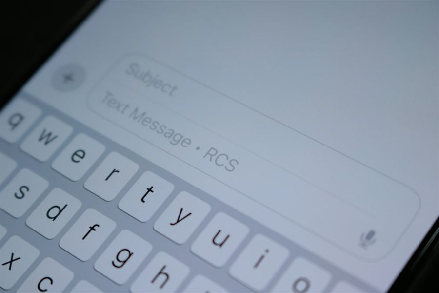 Close-up of a phone keyboard and an empty message field, standing in for a WhatsApp reception flow